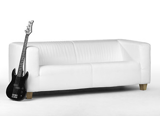 Image showing black bass guitar and white couch