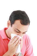 Image showing Young man with a cold blowing nose on tissue 