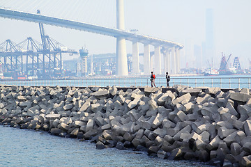 Image showing two people walking on breakwater