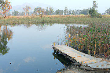 Image showing wooden pier in tranquil lake at morning 