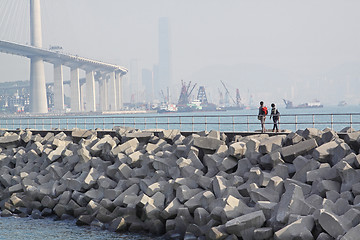 Image showing two people walking on breakwater