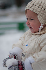 Image showing Little girl plays with snowball