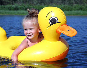 Image showing little girl bathes in river in inflatable duck