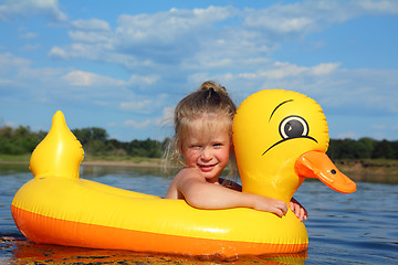 Image showing little girl bathes in river in inflatable duck