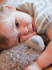 Image showing Little girl hugs her teddy bear