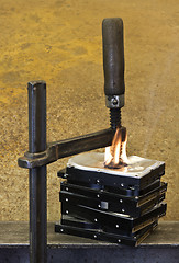 Image showing clamp pressing on burning stack of hard drives