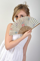 Image showing beautiful girl hiding behind a fan