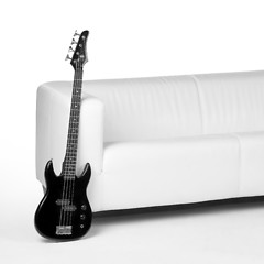 Image showing black bass guitar and white couch