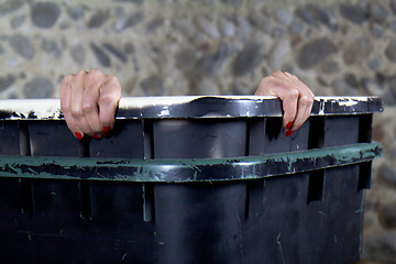 Image showing Woman peeking out of a garbage
