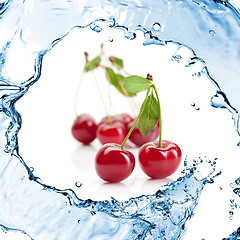 Image showing Red cherry with leaves and water splash isolated on white