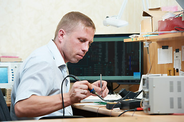 Image showing worker soldering microchip scheme