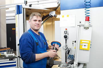 Image showing worker operating CNC machine center