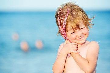 Image showing little girl at sunset in front of red sea