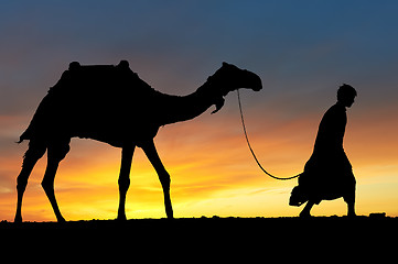 Image showing Silhouette of Arab with camel at sunrise