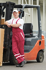 Image showing warehouse worker in front of forklift