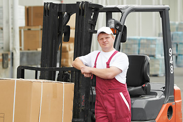 Image showing warehouse worker in front of forklift