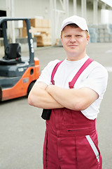 Image showing warehouse worker in front of forklift