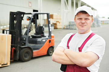 Image showing warehouse worker in front of forklift