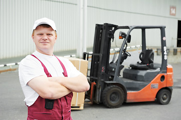 Image showing warehouse worker in front of forklift