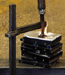 Image showing pressed hard drives with clamp and fire