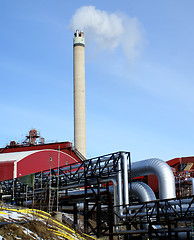 Image showing Industrial zone, Steel pipelines and smokestack against blue sky