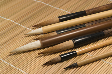 Image showing chinese brushes on wooden mat detail