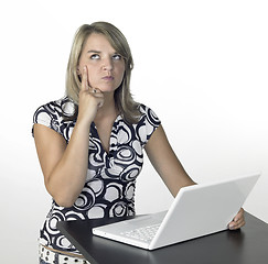 Image showing thinking cute girl above a laptop