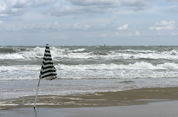 Image showing beach scenery with sunshade and wavy sea