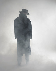 Image showing Woman wearing trench coat and standing in fog