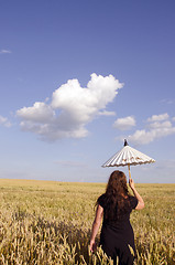 Image showing Young woman walking in the field of wheat.