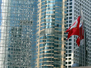 Image showing Flags reflecting in skyscraper windows