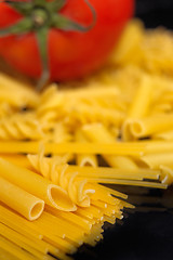 Image showing Italian pasta selection and tomato over black