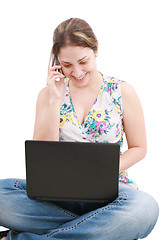 Image showing A pretty young woman sitting on floor with laptop and mobile pho