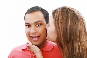 Image showing Young woman kissing her surprised boyfriend, isolated on white