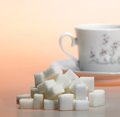 Image showing lump sugar pile and coffee cup in warm light