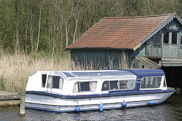 Image showing river boat moored next to a house