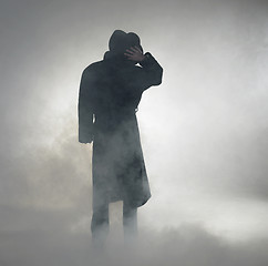 Image showing Woman wearing trench coat and standing in fog