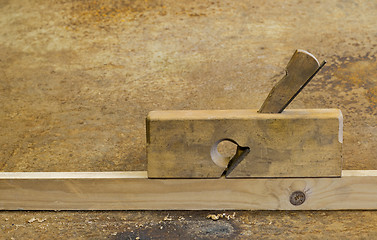 Image showing planer on wood in rusty background