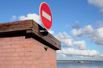 Image showing Road sign brick on building. Pier and sea distance 