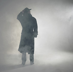 Image showing Woman wearing trench coat and standing in fog