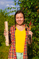 Image showing young woman holding an axe and chock