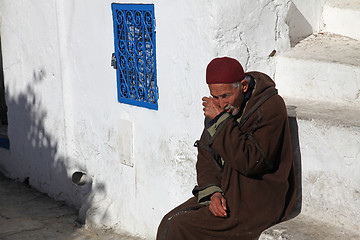 Image showing The old man sitting on the stairs