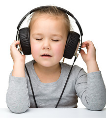 Image showing Cute girl enjoying music using headphones