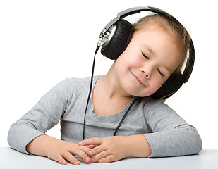 Image showing Cute girl enjoying music using headphones