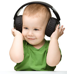 Image showing Cute boy enjoying music using headphones