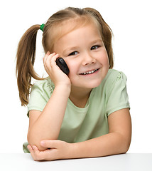 Image showing Cute little girl is talking on cell phone