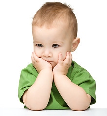 Image showing Pensive little boy support his head with hands