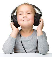 Image showing Cute girl enjoying music using headphones