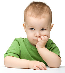 Image showing Pensive little boy support his head with hands