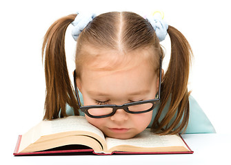 Image showing Little girl is sleeping on a book